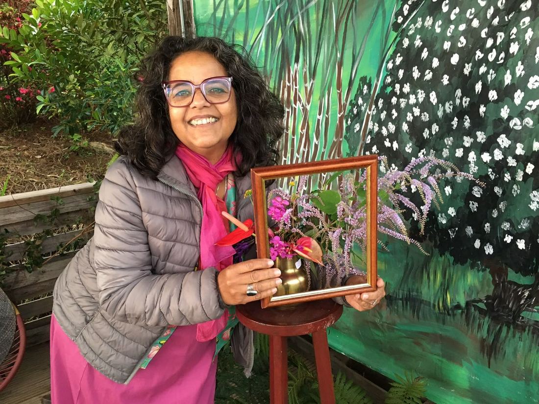Une invitée tenant une petite composition florale encadrée