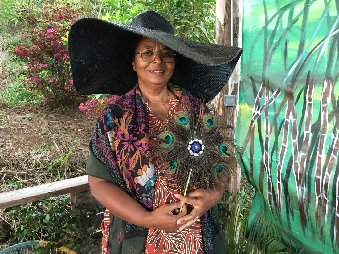 Une invitée avec un large chapeau et un châle à motif de paon