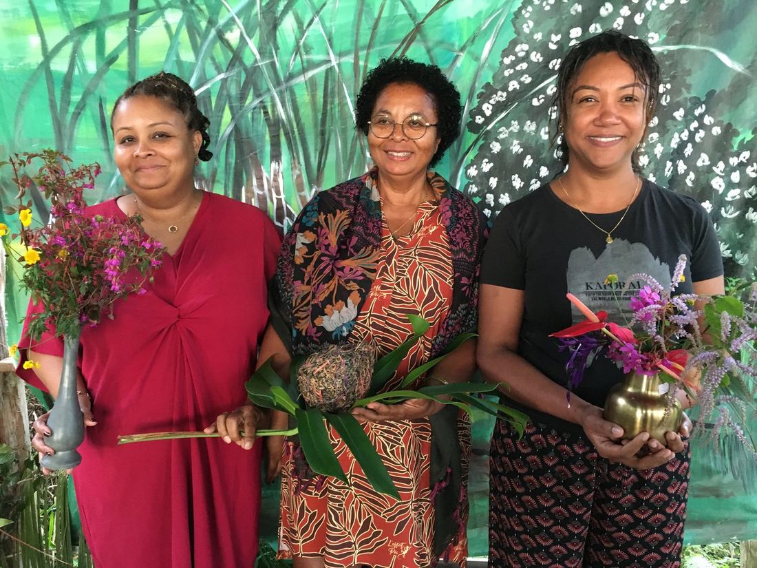 Trois femmes ensemble, chacune tenant un vase de fleurs