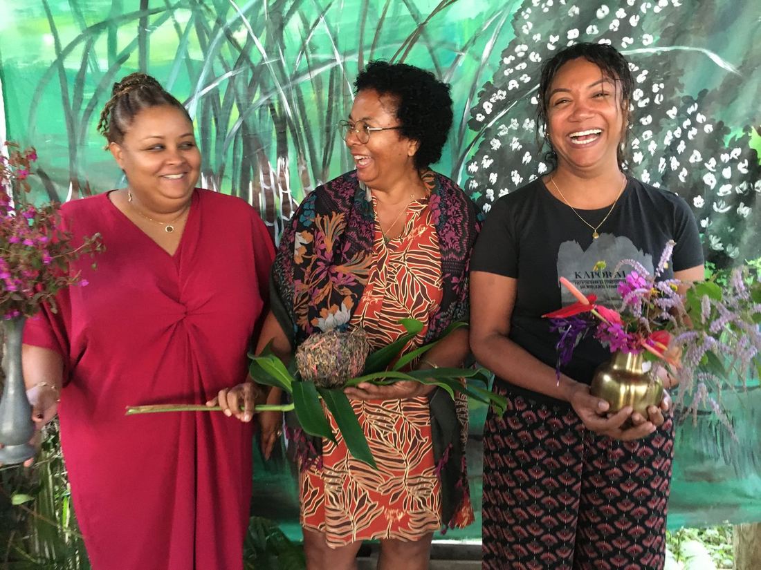 Trois femmes posant ensemble avec des fleurs