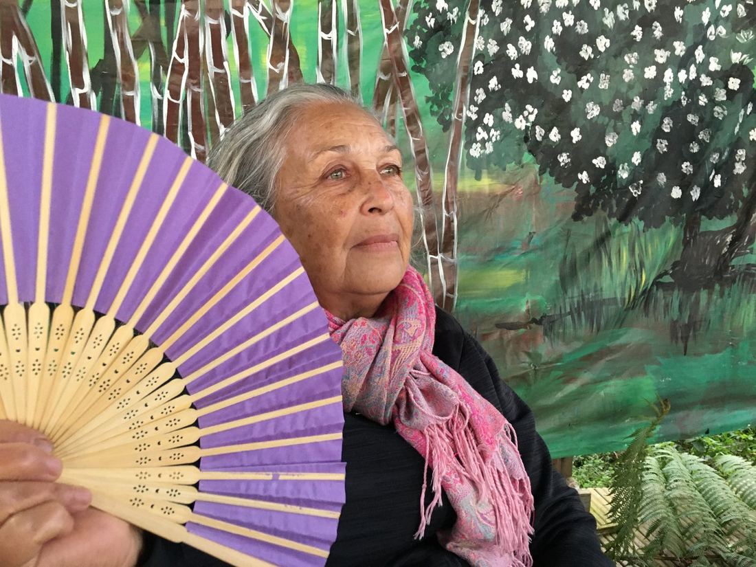 Une invitée avec un éventail violet, assise devant la fresque
